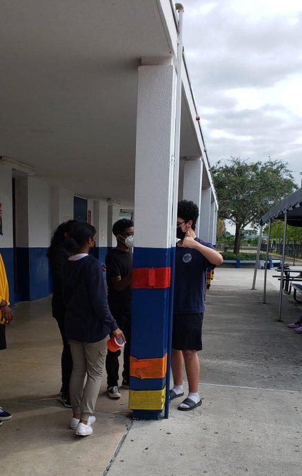 Students wrapping posts with burlap